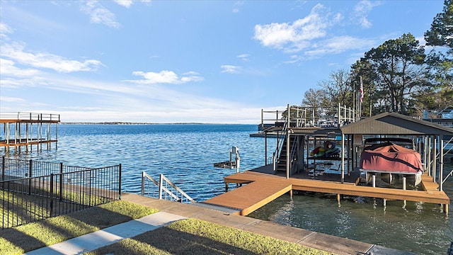 view of dock featuring a water view, fence, and boat lift