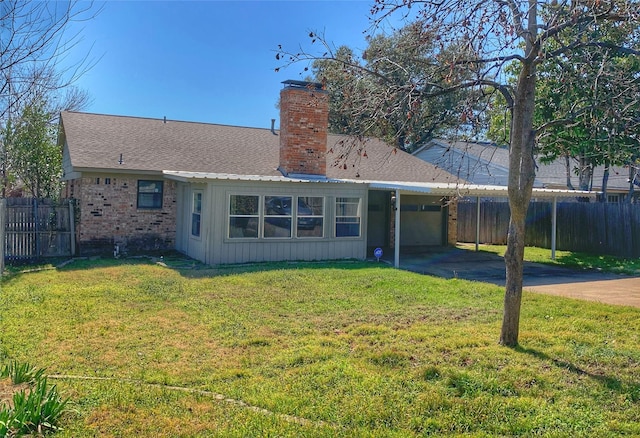 back of property with a garage, fence, driveway, a lawn, and a chimney