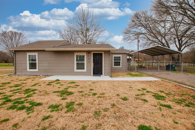 back of house featuring a gate, fence, and a detached carport