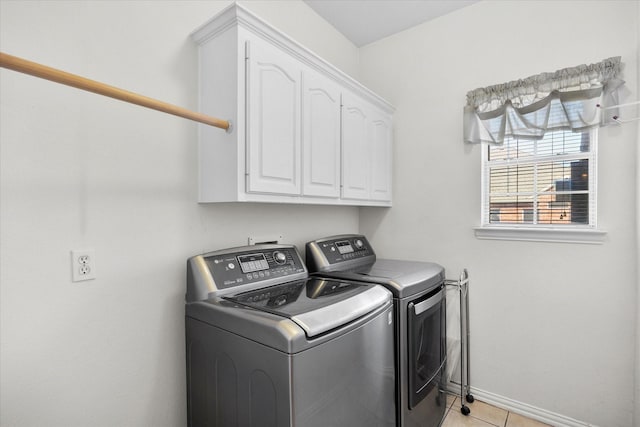 laundry room with light tile patterned floors, washer and clothes dryer, cabinet space, and baseboards