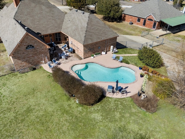 pool with a fenced backyard, a patio, and a lawn