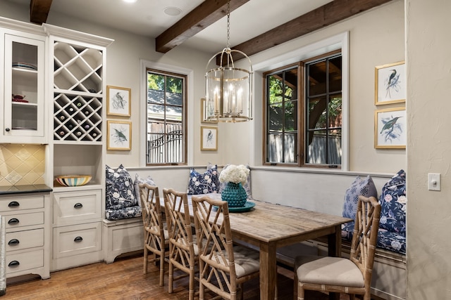 dining room featuring beamed ceiling, light wood finished floors, breakfast area, and plenty of natural light