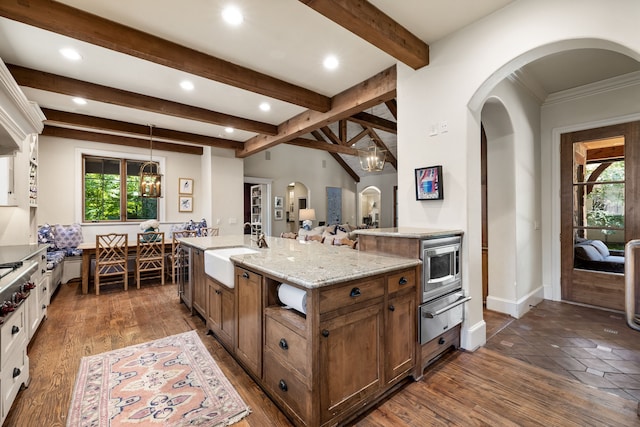 kitchen with arched walkways, a healthy amount of sunlight, a warming drawer, and a sink