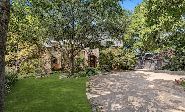 view of front of home featuring stone siding and a front yard