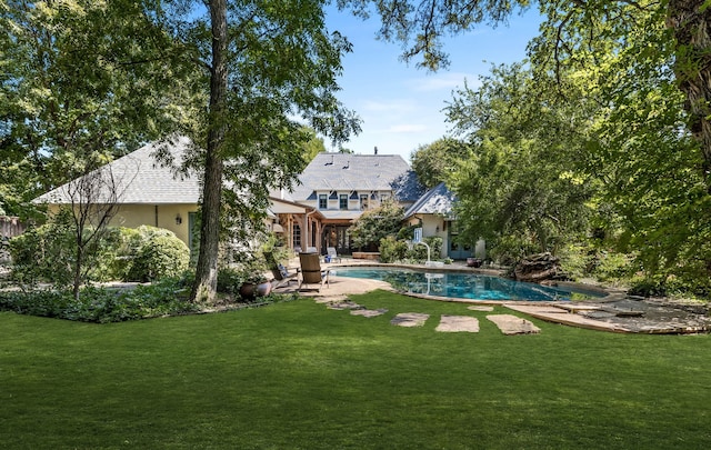 rear view of house featuring an outdoor pool, a patio area, stucco siding, and a yard