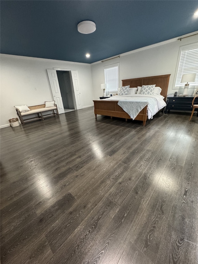 unfurnished bedroom featuring crown molding, baseboards, and wood finished floors