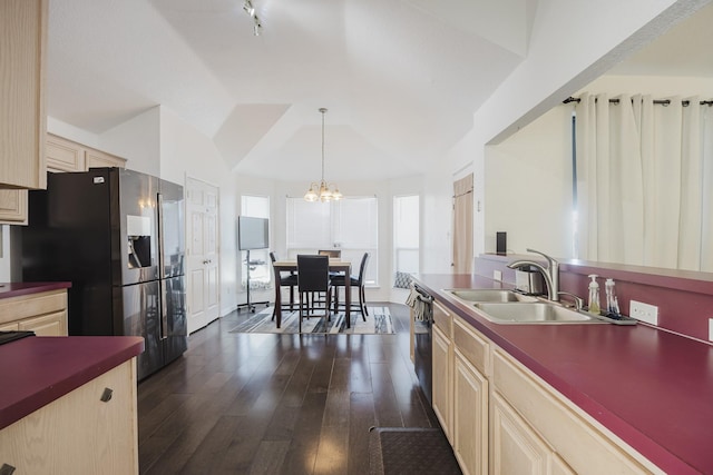 kitchen featuring a sink, stainless steel fridge with ice dispenser, dishwasher, light brown cabinetry, and dark wood finished floors