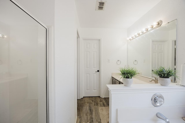 bathroom featuring a stall shower, visible vents, and wood finished floors