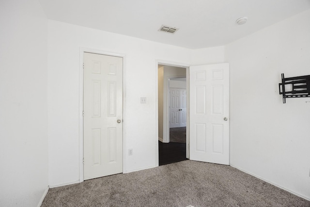 unfurnished bedroom featuring carpet and visible vents