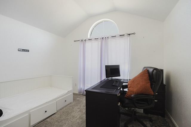 carpeted home office featuring vaulted ceiling