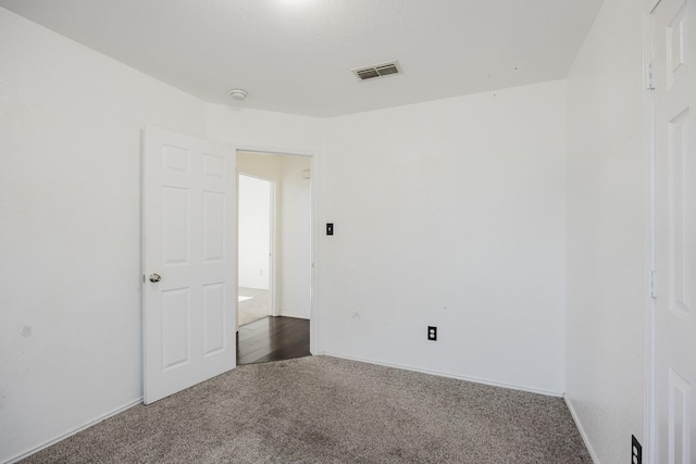 empty room with visible vents and carpet flooring