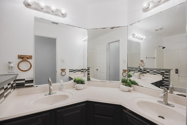 full bath featuring double vanity, a sink, and visible vents