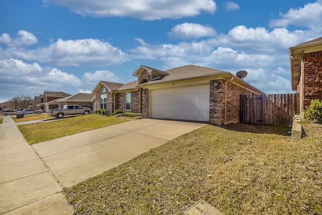 traditional-style house with a garage, brick siding, fence, concrete driveway, and a front yard