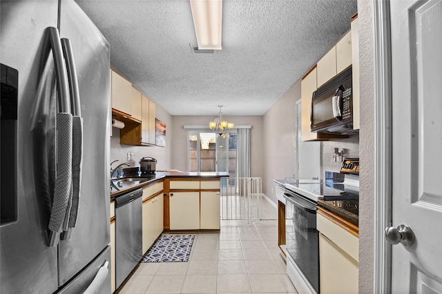 kitchen with light tile patterned floors, stainless steel appliances, a peninsula, a sink, and dark countertops