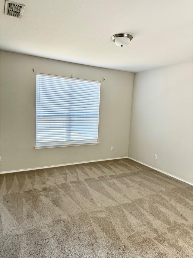 carpeted spare room featuring visible vents