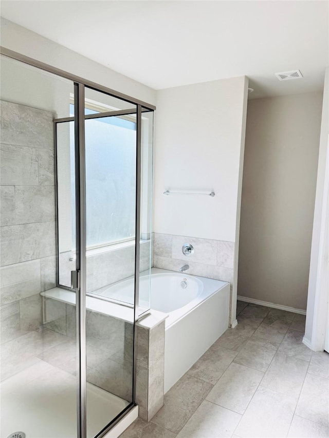 bathroom with visible vents, a garden tub, and a shower stall