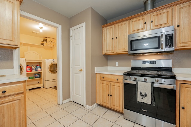 kitchen with appliances with stainless steel finishes, washer / clothes dryer, and light brown cabinetry