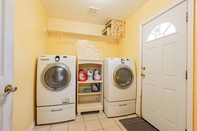 laundry area featuring laundry area, light tile patterned floors, visible vents, and separate washer and dryer