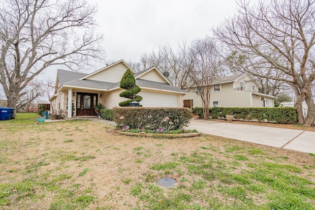 view of front of house featuring an attached garage, brick siding, concrete driveway, and a front yard