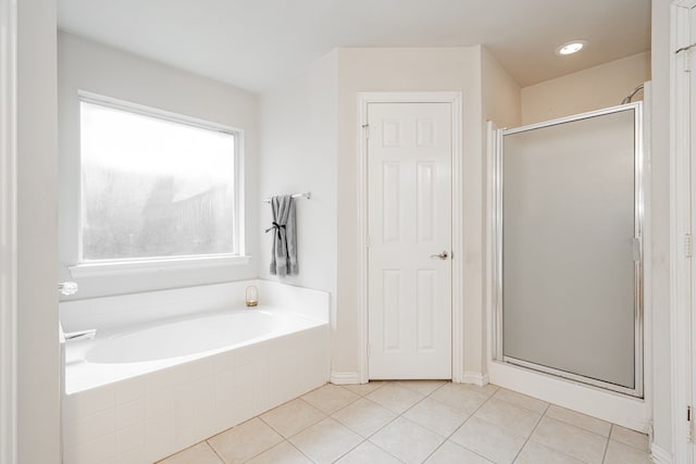 full bathroom with a shower stall, a bath, and tile patterned floors