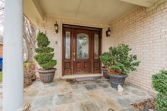 doorway to property with brick siding