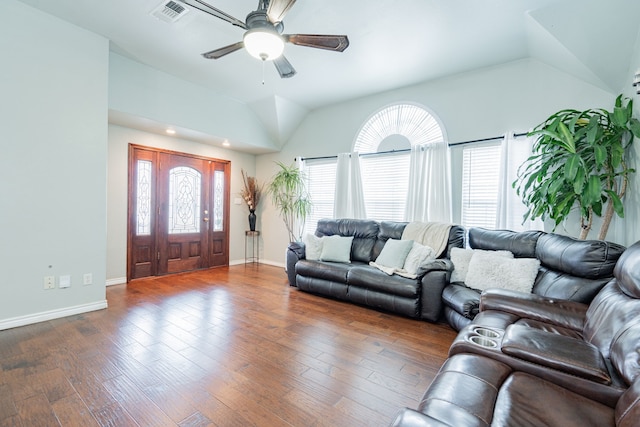 living room with lofted ceiling, visible vents, baseboards, and wood finished floors