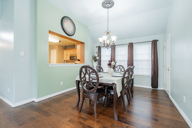 dining room with lofted ceiling, dark wood-style flooring, baseboards, and an inviting chandelier