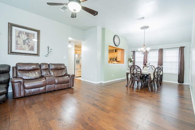 interior space featuring ceiling fan with notable chandelier, lofted ceiling, visible vents, and wood finished floors