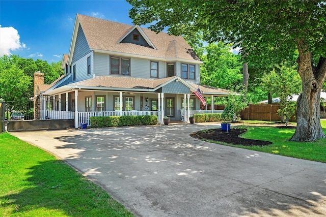 view of front of home featuring driveway, a shingled roof, covered porch, fence, and a front lawn