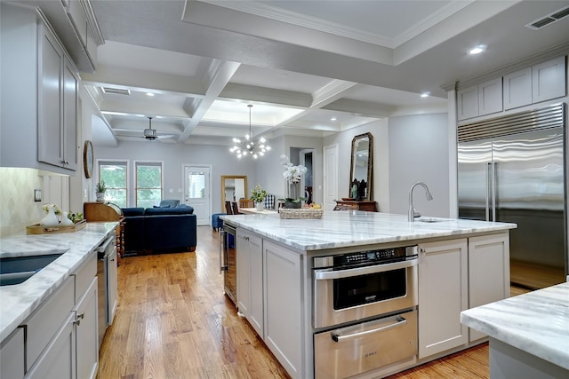 kitchen featuring coffered ceiling, visible vents, open floor plan, appliances with stainless steel finishes, and a warming drawer