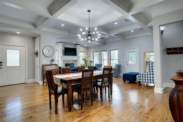 dining area with visible vents, coffered ceiling, light wood-style flooring, a fireplace, and beam ceiling