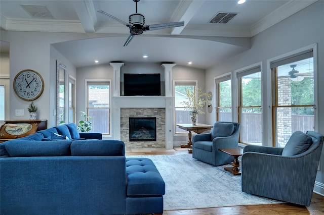 living room featuring a wealth of natural light, visible vents, a fireplace, and wood finished floors