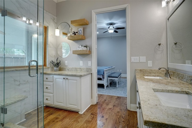 bathroom featuring ensuite bathroom, ornamental molding, a sink, a shower stall, and wood finished floors