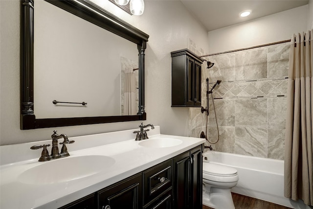 full bath featuring shower / bath combo, a sink, toilet, and wood finished floors