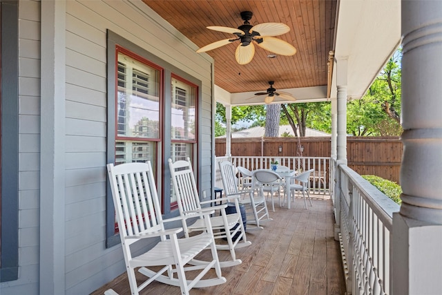 view of patio with covered porch, ceiling fan, fence, and outdoor dining space