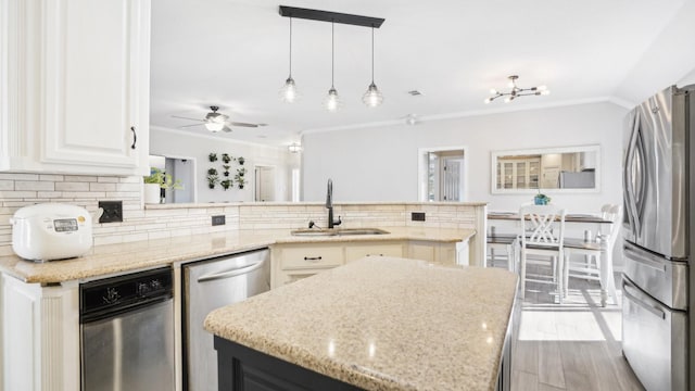 kitchen with a sink, tasteful backsplash, appliances with stainless steel finishes, and ornamental molding