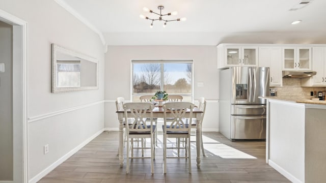 dining room featuring recessed lighting, an inviting chandelier, baseboards, and light wood-style floors