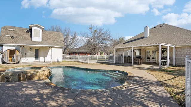 view of pool with french doors, a pool with connected hot tub, a patio, and fence