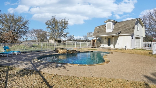 view of swimming pool featuring a patio, a pool with connected hot tub, and a fenced backyard