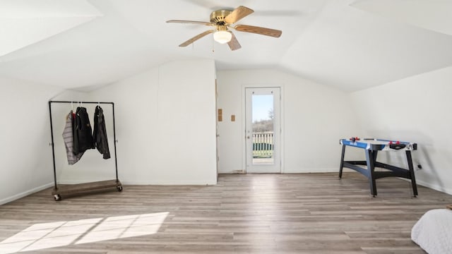 additional living space featuring a ceiling fan, lofted ceiling, wood finished floors, and baseboards