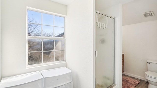 full bathroom featuring visible vents, toilet, wood finished floors, and a shower stall