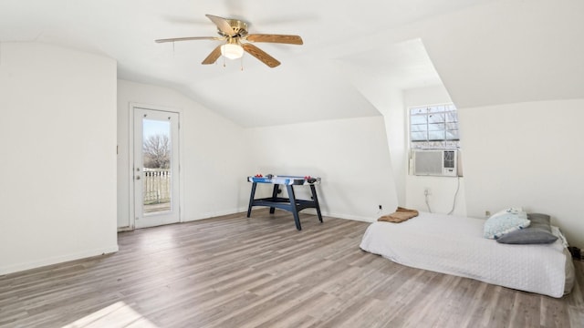 bedroom featuring multiple windows, wood finished floors, lofted ceiling, and access to outside