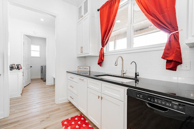 kitchen featuring light wood finished floors, white cabinets, dishwasher, backsplash, and a sink