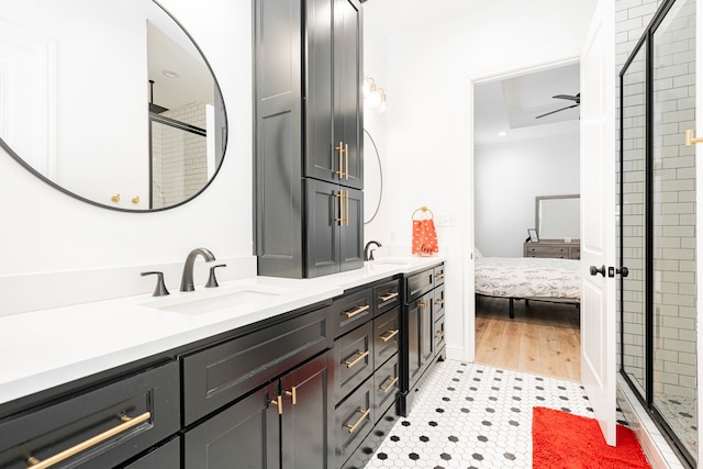 ensuite bathroom featuring double vanity, a shower stall, a ceiling fan, and a sink