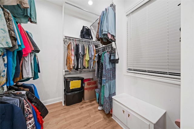 walk in closet with light wood-style floors