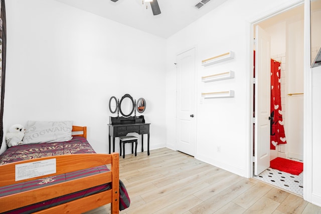 bedroom featuring ceiling fan, wood finished floors, visible vents, and baseboards