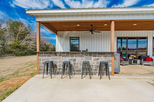 view of patio featuring a bar and ceiling fan