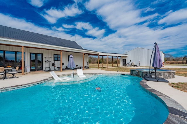 view of swimming pool featuring a pool with connected hot tub, french doors, and a patio