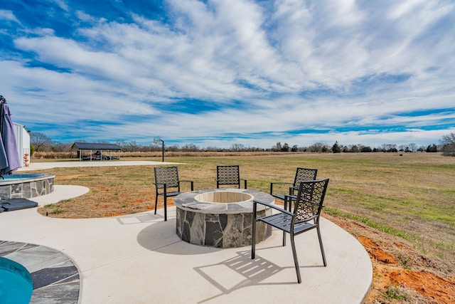 view of patio / terrace with an outdoor fire pit and a rural view