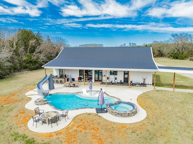 view of pool with a yard, an outdoor fire pit, a water slide, and a patio